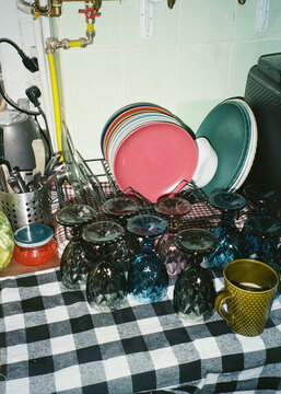 Cafe owner organizes dishes and glassware in small restaurant