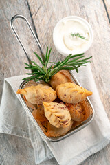 Fried Chinese dumplings or gyoza on a wooden table with sauce. Top view