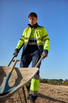Worker with wheelbarrow and shovel