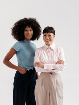 Confident  Female Colleagues Smiling at Camera in Studio Setting