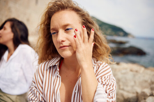 Woman puts on sunscreen for her face