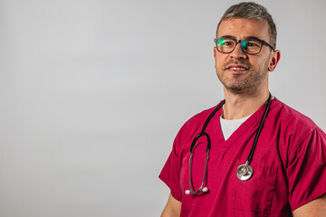 Smiling male doctor in scrubs with stethoscope posing for a portrait