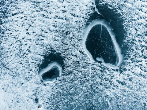 Aerial View of Two Ice Holes on Frozen Lake