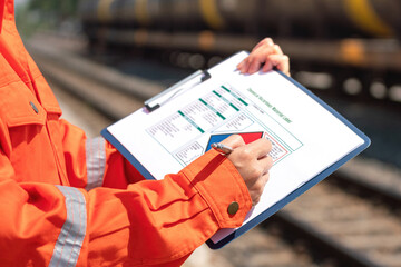 Action of an engineer is checking on the chemical hazard material form with background of crude oil...