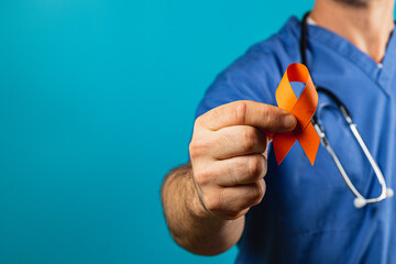 Medical professional holding orange ribbon for awareness campaign
