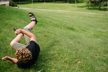 The boy rolls down the hill.