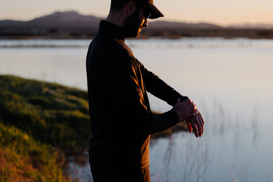 Silhouette of sporty adult reviewing his fitness data on a smartwatch