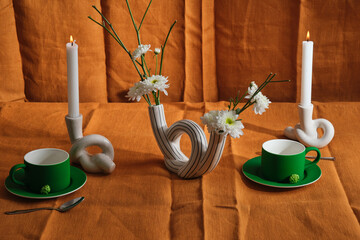 candle composition with flowers and natural textiles, green cups, tea ceremony