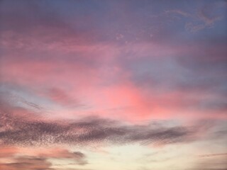 Fototapeta premium The evening sky is blue with multi-colored clouds, white, grey, pink, purple, golden yellow, orange, and vanilla.