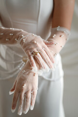 Beautiful bride in white wedding dress and gloves, close-up