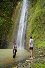 small group of happy young asian people exploring waterfall