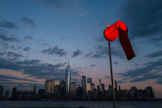 Red windsock with dramatic sunset and urban background
