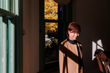 A happy Asian woman lost in thought in the light.