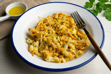 Delicious golden Portuguese cod dish cooked with fried potatoes and egg. Traditional Portuguese recipe with cod.