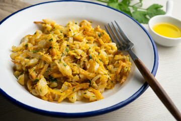 Delicious golden Portuguese cod dish cooked with fried potatoes and egg. Traditional Portuguese recipe with cod.