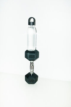 Workout equipments dumbbell and waterbottle with hard direct flash