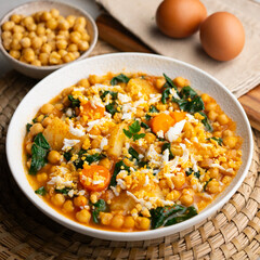 Delicious stew of potatoes and chickpeas stewed with spinach, vegetables and boiled egg. Traditional Spanish recipe.