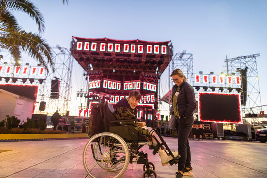 Woman and disabled child wait for a concert to start in a city square