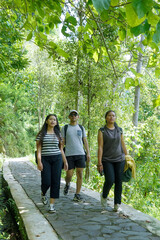 Obraz premium group of happy young asian indonesian people walking together on the walk path in the park
