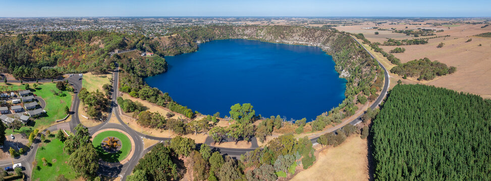 Road encircling a large blue volcanic lake
