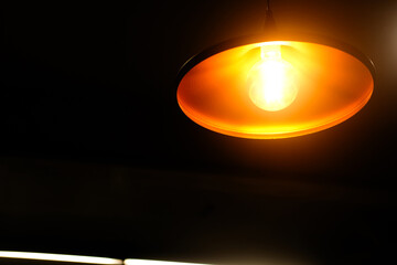 Round pendant lights hang from the ceiling and cast soft orange light