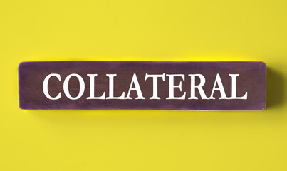 COLLATERAL - word on a wooden block close-up on a yellow background