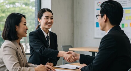 Three Business People Shaking Hands During An Interview