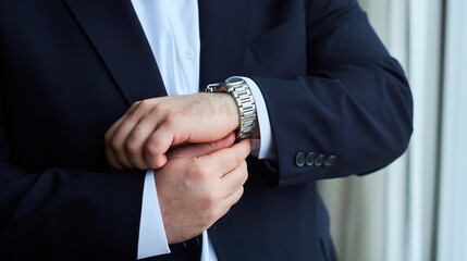 A man in a suit is wearing a watch and adjusting his jacket. Concept of formality and attention to detail, as the man takes care to ensure his appearance is polished and professional