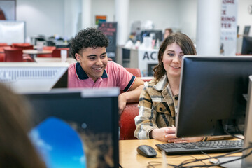 Classmates Laughing At Something On Computer