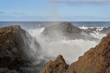 Waves crashing against volcanic rocks........