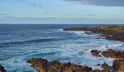 Waves crashing on volcanic shore