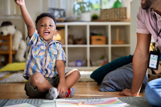 Little boy eagerly raising his hand