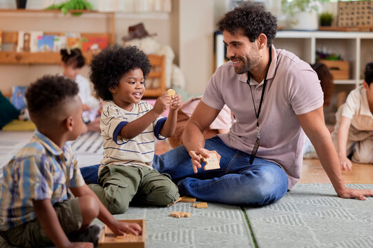 Happy caretaker playing puzzle game with children