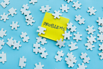 Scattered Puzzle Pieces with Yellow Sticky Note Reading 