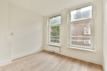 A spacious and bright interior featuring large windows and light wooden flooring, perfect for creating a serene living environment.