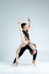 Sporty Asian Man and Caucasian Woman Performing As Ballet Dancers On Grey in Studio During Suppots As Classical Dance And Choreography © danmorgan12