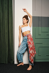 Fototapeta premium A mid-adult woman posing stylishly in a modern indoor setting with artistic decor