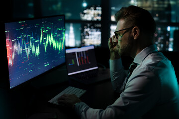 Smart stock market analyst working in front of skyline window