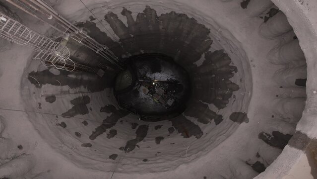 Deep industrial excavation with cables and machinery