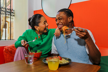 Couple enjoying a delicious pasta and salad together at restaurant