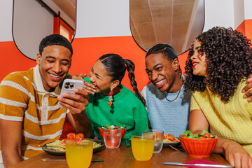 Young people enjoying meal and social media at restaurant