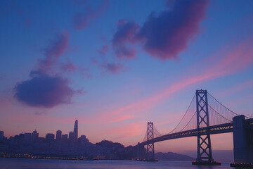 Obraz premium San francisco skyline and bay bridge emerging in the pink and purple dawn
