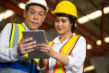 Obraz premium Trainee. Asian Factory worker training to apprentice colleague on production line in Heavy Industry Manufacturing Facility. Instructor with Trainee working at factory