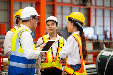 Unity and teamwork. Asian team engineer worker working control sheet metal roof tile roll forming machine at metal sheet profiling factory. Industrial production