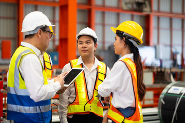 Unity and teamwork. Asian team engineer worker working control sheet metal roof tile roll forming...