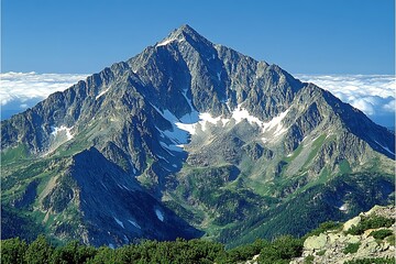 Majestic Mountain Peaks Tower Above Clouds On A Bright Day