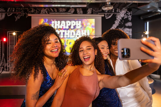 Friends capturing joy selfie at a lively birthday celebration