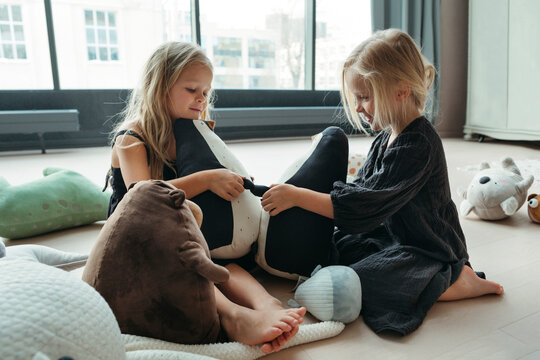 Sisters Enjoying Playtime With Cuddly Toys Indoors