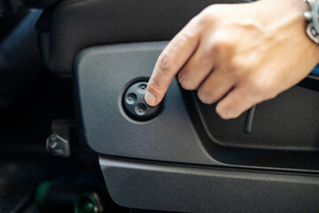 Close up of hand pushing seat button in a car.