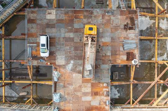 Aerial View of Construction Site with Vehicles and Building Fram
